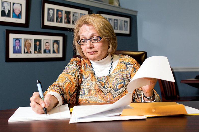 Rae Ann Fields, executive director of the Bryant Chamber of Commerce, looks through scholarship applications at the chamber office. The chamber is collecting money to give 25 $500 scholarships to Bryant High School seniors who will attend college this fall. This is the 14th year for the scholarship program.