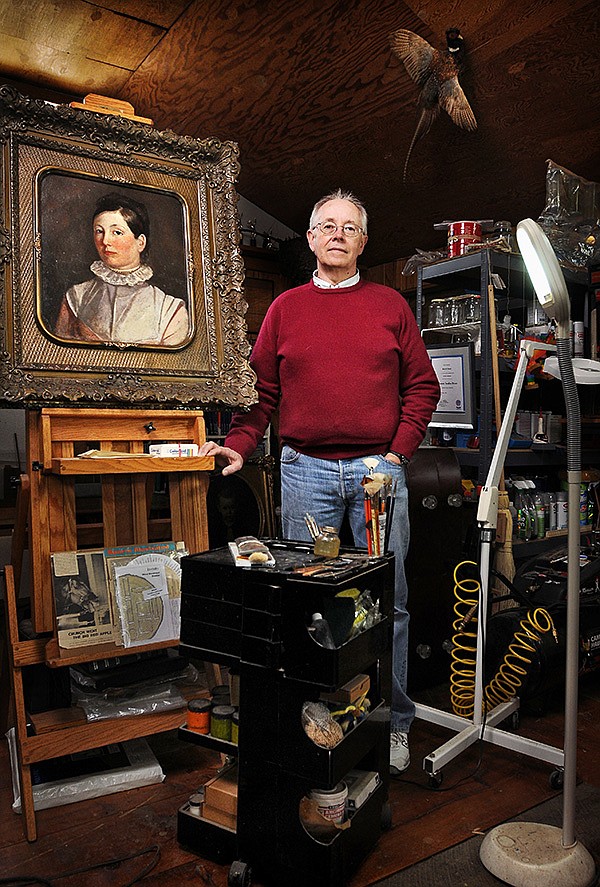   NWA Media/BEN GOFF 
Conservator Rick Parker poses for a photo with one of his restoration projects, a painting by Samuel Morse that dates to around 1840, on Wednesday in his workshop in Gentry. Parker, who recently returned from Cuba surveying United Nations World Heritage sites, is a private conservator on staff with the Smithsonian Institution who specializes in restoring wooden artifacts.