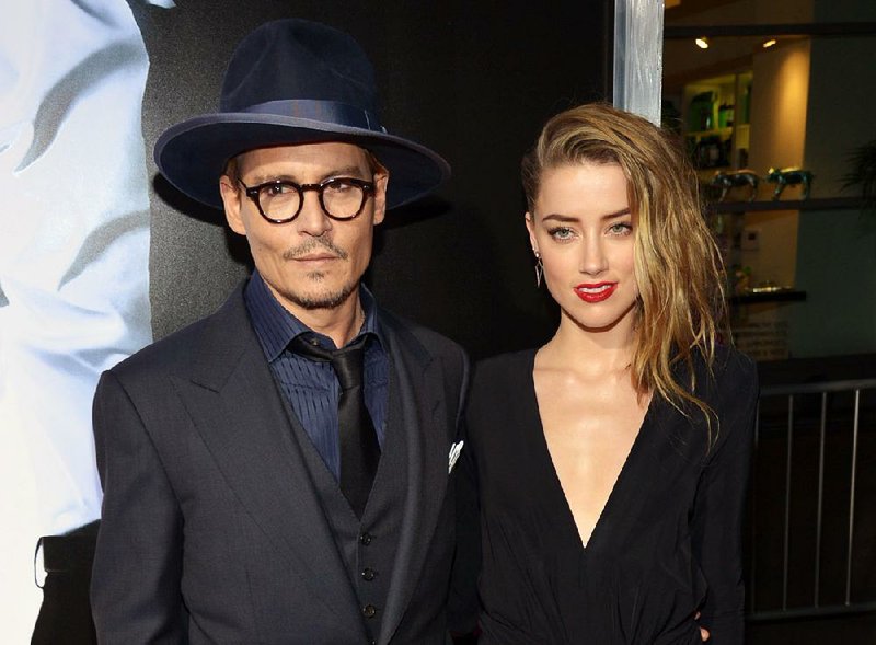 FILE - This Feb. 12, 2014 file photo shows Johnny Depp, left, and Amber Heard at the US premiere of "3 Days to Kill" at ArcLight Cinemas Hollywood in Los Angeles.