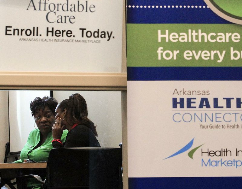 Arkansas Democrat-Gazette/BENJAMIN KRAIN --3/31/2014--
Pamela Abrams, left, an In Person Assistor with Future Builders, assists people at the Laman Library in North Little Rock, with health care provider sign up and questions Monday during the final day of enrollment in the Affordable Health Care Act.