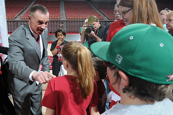 Jimmy Dykes, left, speaks to Grace Kilcrease, 9, after a press conference introducing him as the eighth women's head basketball coach Sunday, March 30, 2014, at Bud Walton Arena in Fayetteville.