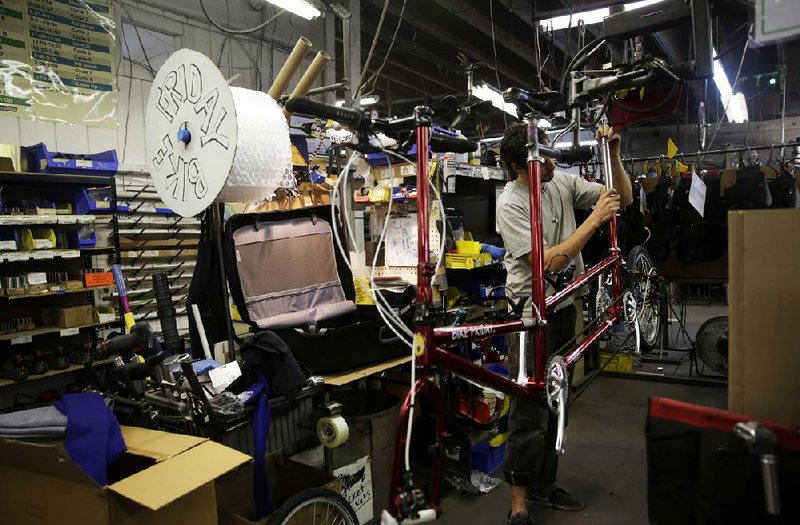 An employee disassembles a bicycle for shipment at the Bike Friday factory in Eugene, Ore., last week. Manufacturing grew at a slightly faster pace in March compared with February, the Institute for Supply Management said Tuesday. 