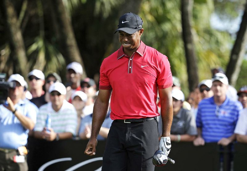 Tiger Woods grimaces in pain after teeing off March 9 during the Cadillac Championship in Doral, Fla. Woods, a four-time Masters champion, will miss the tournament next week after undergoing a microdiscectomy Monday for a pinched nerve in his back. 