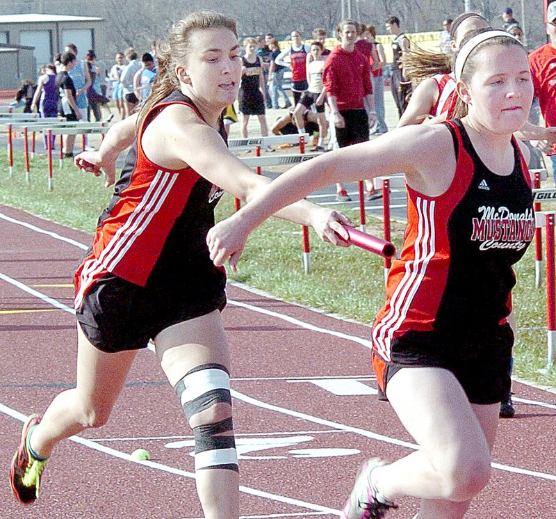 RICK PECK MCDONALD COUNTY PRESS McDonald County&#8217;s Kayleigh Jones hands off to Hanna Schmit in the 2x200 relay at the 9/10 Mustang Stampede held Monday at MCHS.