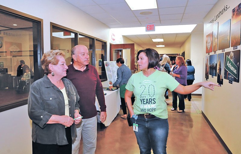 STAFF PHOTO FLIP PUTTHOFF Jackie and Will Keller, from left, tour the Northwest Arkansas Children's Shelter on Tuesday with their granddaughter, Kalyna Keller, a shelter employee. A ceremony marking the 20th anniversary and was held in the gym and recognized founders, administrators, staff and former shelter residents.