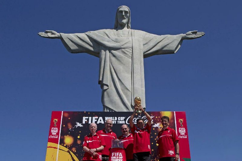 Former members of Brazil’s national soccer team pose beneath the Christ the Redeemer statue in September for the start of the FIFA World Cup Trophy Tour in Rio de Janeiro. 