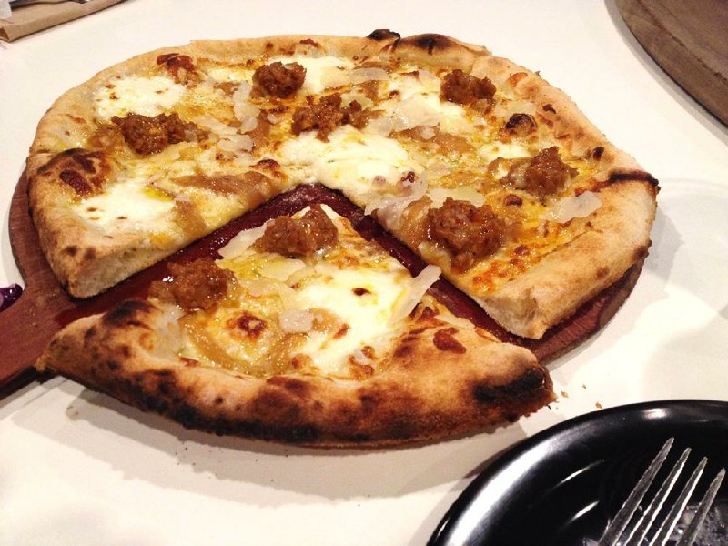 The Wise Guy, a pizza special at ZaZa Fine Salad & Wood Oven Pizza Co. in the Heights, features light mozzarella, curd, garlic, onion, sausage and shaved Parmesan on an extra-virgin olive oil base. 
