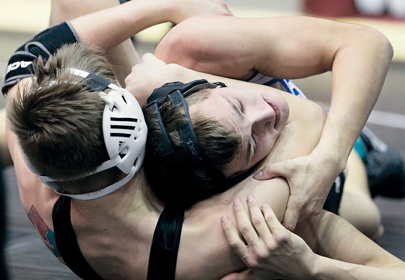 Maumelle’s Justin Butler, left, defeated Bismarck’s Aaron Whitehead in the Class 1A-5A 160-pound weight class of the high school state wrestling tournament. The victory was Butler’s third straight state championship.