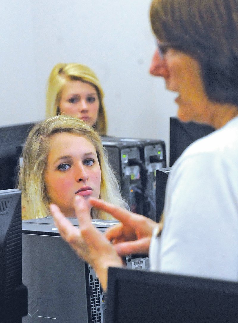 STAFF PHOTO FLIP PUTTHOFF Kelsie Galyean, left, and Sadie Robertson, both students at Pea Ridge High School, listen to Ann Turner talk about student financial aid at NorthWest Arkanas Community College in Bentonville.