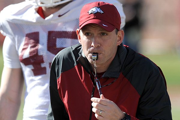 Arkansas defensive coordinator Robb Smith directs his players as linebacker Alex Brignoni listens during practice Thursday, March 20, 2014, at the UA practice field in Fayetteville.