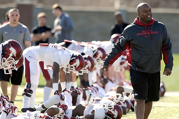 Arkansas defensive backs coach Clay Jennings walks past his players during practice Thursday, March 20, 2014, at the UA practice field in Fayetteville.