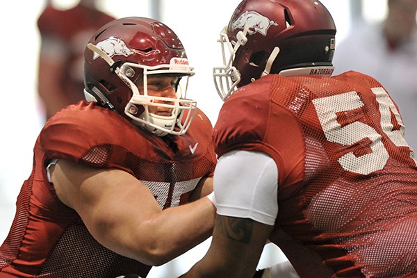 Arkansas center Luke Charpentier runs drills during Thursday afternoon's practice in Fayetteville.