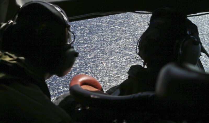 Wing commander Rob Shearer captain of the Royal New Zealand Air Force P3 Orion left, and Sgt. Sean Donaldson look out the cockpit windows during search operations for missing Malaysia Airlines Flight MH370 in the southern Indian Ocean, near the coast of Western Australia, Friday, April 4, 2014.