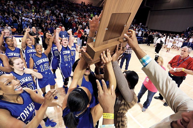 The Conway Lady Wampus Cats celebrate with their trophy after beating Fort Smith Northside in the state Class-7A girls championship game in Hot Springs.