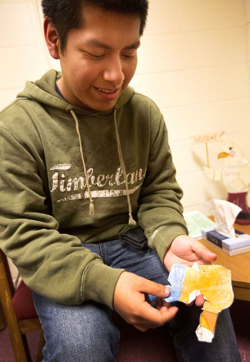 Huntsville High School senior Alan Orduna unfolds the remains of a Flat Stanley that spent nine years in a soldier’s back pocket after Orduna’s third-grade teacher mailed it to an Army unit in Iraq in 2004. 