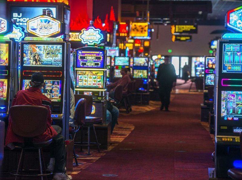 Players watch carefully (above) for a win on the gambling floor inside the Choctaw Casino Hotel in Pocola, Okla. The Indian-owned gambling operations draw a large number of Arkansas gamblers, which contributed to rising revenue for the Oklahoma casinos. 