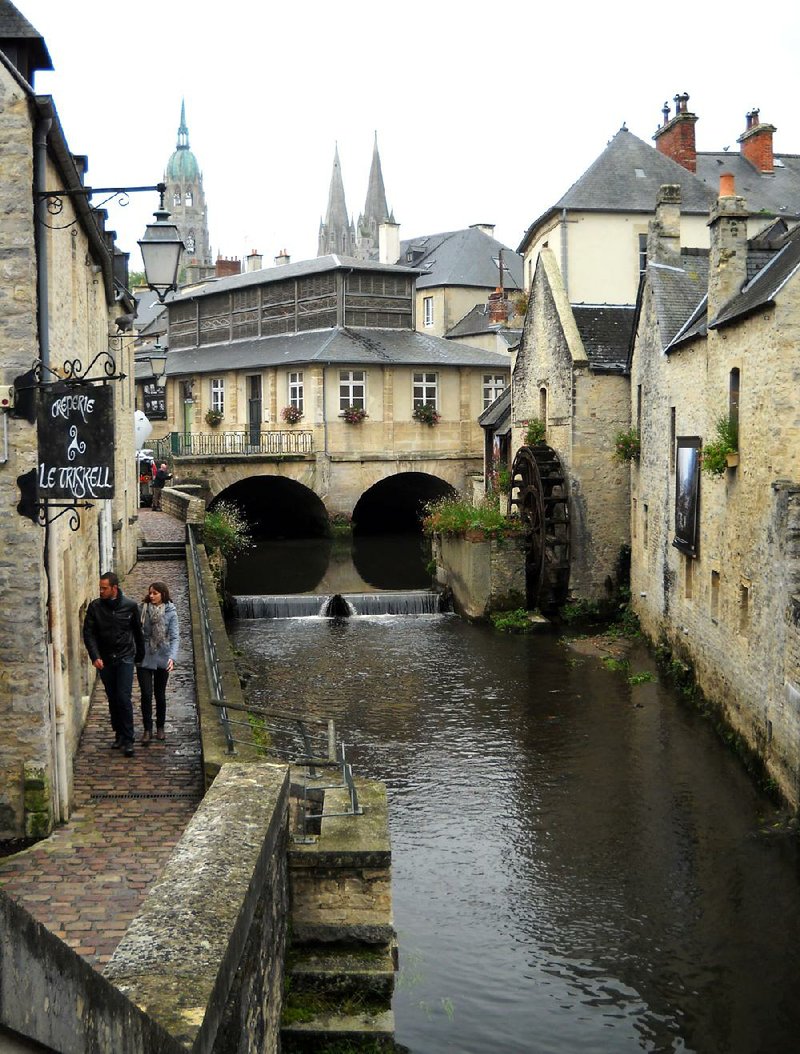 Pedestrians walk along the Aure River in Bayeux, France. The charming town sits just a few miles from the beaches of Normandy where Allied forces invaded on D-Day during World War II in 1944. 
