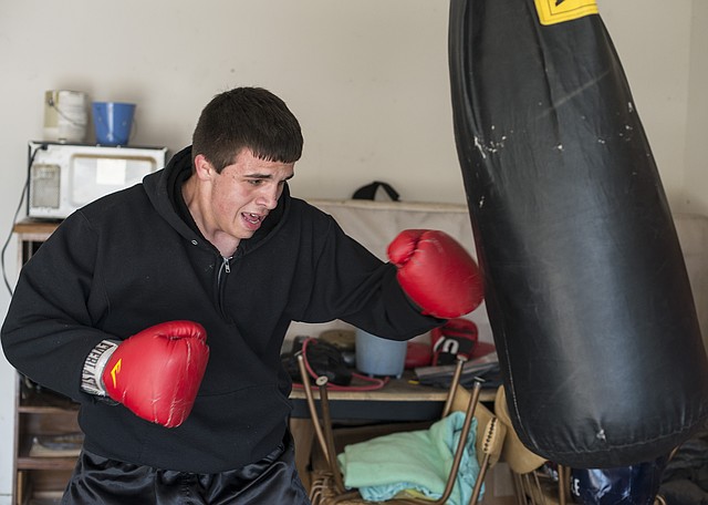  STAFF PHOTO ANTHONY REYES Thomas Sloman of Rogers works out Friday at his home in Rogers. Sloman recently won the 178-pound weight division of the Arkansas Gold Gloves Boxing Championships.