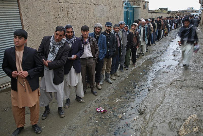 Afghan men line up for registration process before they cast their votes at a polling station in Kabul, Afghanistan, Saturday, April 5, 2014. Afghans flocked to polling stations nationwide on Saturday, defying a threat of violence by the Taliban to cast ballots in what promises to be the nation's first democratic transfer of power. 