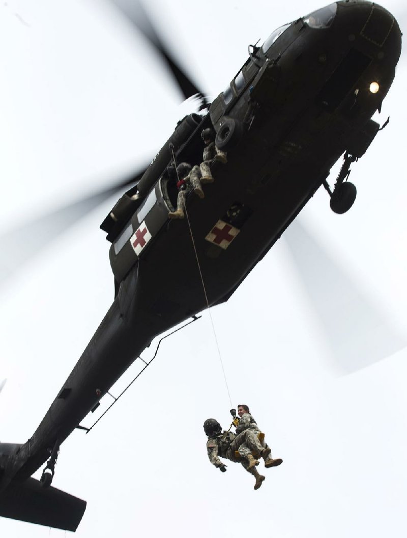 Arkansas Democrat-Gazette/MELISSA SUE GERRITS - 04/05/2014 - Soldiers with the 77th Theater Aviation Brigade from camp Robinson conduct an aerial hoist rescue training at Pinnacle Mountain State Park April 5, 2014. The exercise utilized a UH-60 Black Hawk helicopter and simulated one rescue of a stretcher and manican at marker 5 on Pinnacle Mountain and two hoists of people from the top of Pinnacle Mountain. 