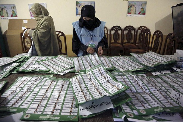 Afghan election workers check ballots Saturday at a polling station in Jalalabad. Amid heavy turnout nationwide, officials said as many as 7 million Afghans were expected to vote. 