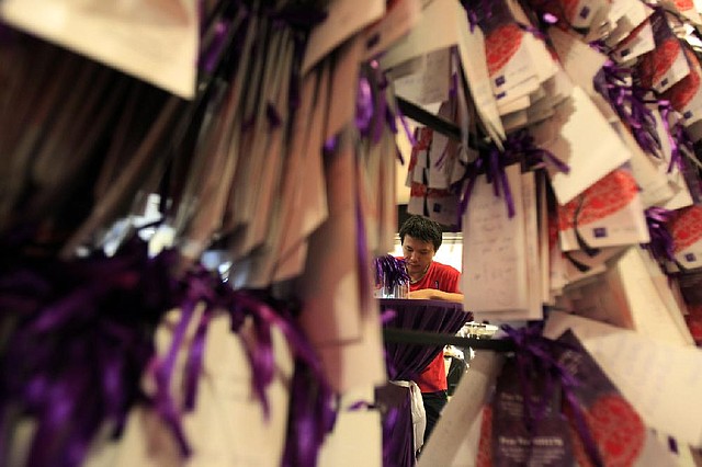 At a mall Saturday in Kuala Lumpur, Malaysia, a man writes a message to add to the many hanging there for the people aboard the missing Malaysian jetliner. 