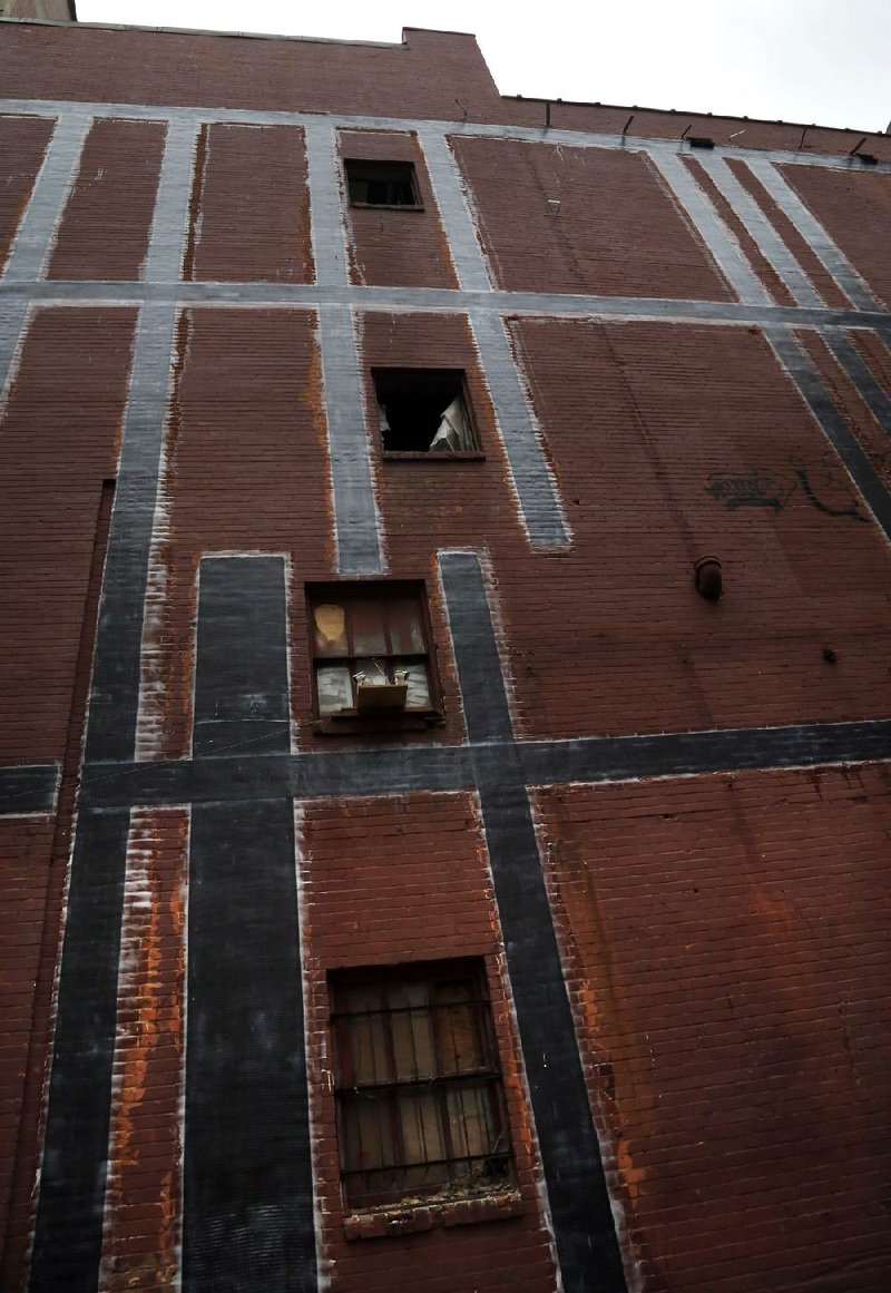 Arkansas Democrat-Gazette/JOHN SYKES JR. The black mesh-like material on the back of the Arkansas Building on Main Street in downtown Little Rock takes the place of more traditional structural reinforcement techniques. 040214. 