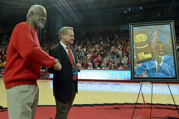 Former University of Arkansas basketball coach Nolan Richardson shakes the hand of David Gearhart, University of Arkansas Chancellor, during a presentation of a painting of Richareson on Saturday, Feb. 2, 2013 at Bud Walton Arena in Fayetteville.