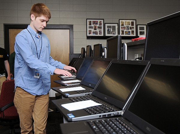 STAFF PHOTO BEN GOFF 
Cole Cable, 18, a Bentonville High School senior, prepares new laptops Wednesday destined for use at Washington Junior High at the Bentonville School District Technology Center. Cable is a participant in the district’s Technology Apprentice program.