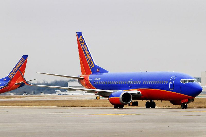 A Southwest Airlines Co. Boeing 737-3H4 plane moves along a runway at Dallas Love Field Airport in Dallas, Texas, U.S., on Monday, Feb. 3, 2014. Southwest Airlines Co., the largest domestic carrier, will begin flying to 15 new destinations from Dallas Love Field when flight restrictions at the airport closest to downtown end in October. Photographer Ben Torres/Bloomberg