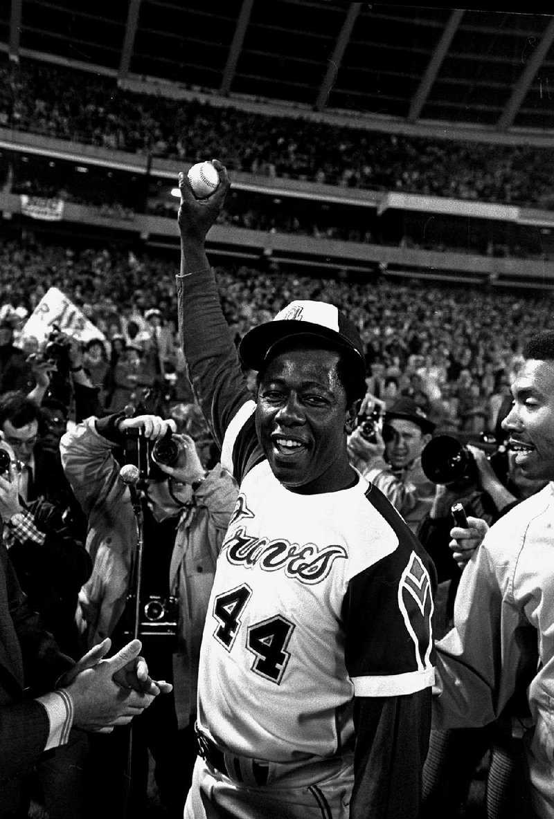 FILE - In this April 8, 1974 file photo, Atlanta Braves baseball player Hank Aaron holds the ball he hit for his 715th home run during a game against the Los Angeles Dodgers, in Atlanta. (AP Photo/Bob Daugherty, File)