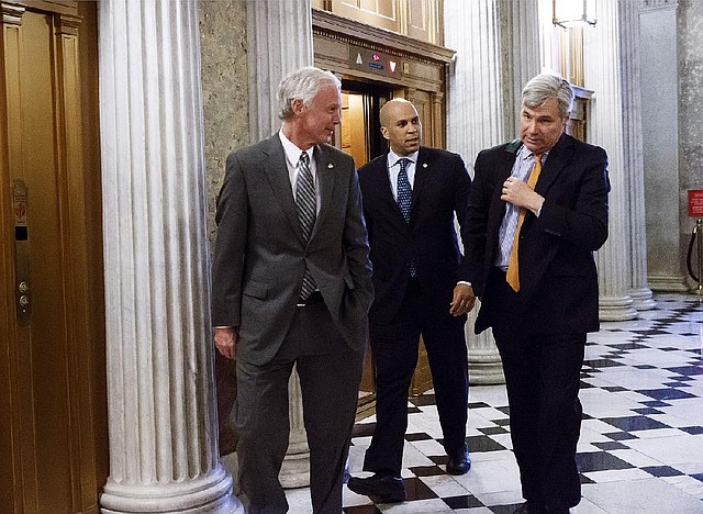 Sen. Ron Johnson, R-Wis., left, Sen. Cory Booker, D-N.J., center, and Sen. Sheldon Whitehouse, D-R.I., head to the chamber during the vote on restoring jobless benefits for the long-term unemployed, legislation that expired late last year, at the Capitol in Washington, Monday, April 7, 2014. With their 17-day spring break beckoning at the end of the week, House and Senate lawmakers will have to scramble to reach agreement. (AP Photo/J. Scott Applewhite)
