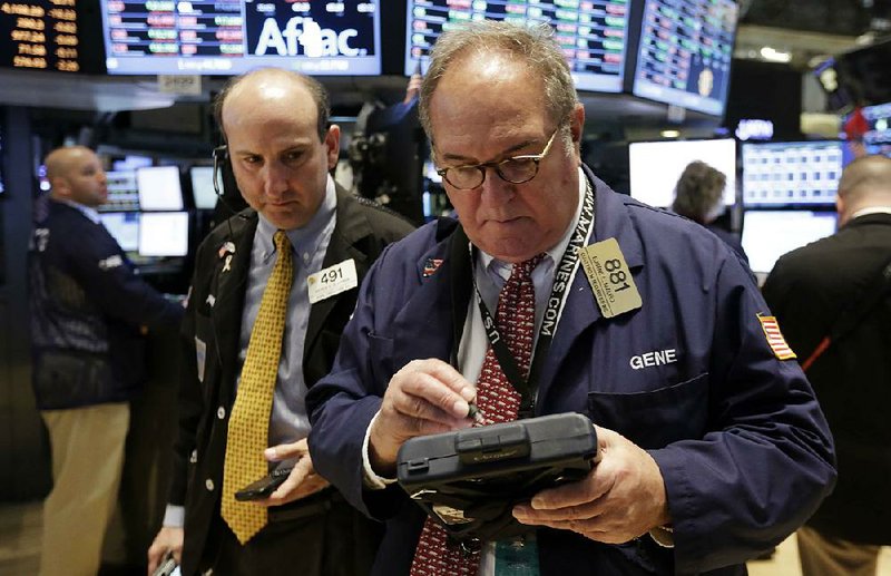 Traders Andrew Silverman, left, and Eugene Mauro work on the floor of the New York Stock Exchange, Monday, April 7, 2014.  Stocks are starting out the week the same way they ended the last one, down. (AP Photo/Richard Drew)