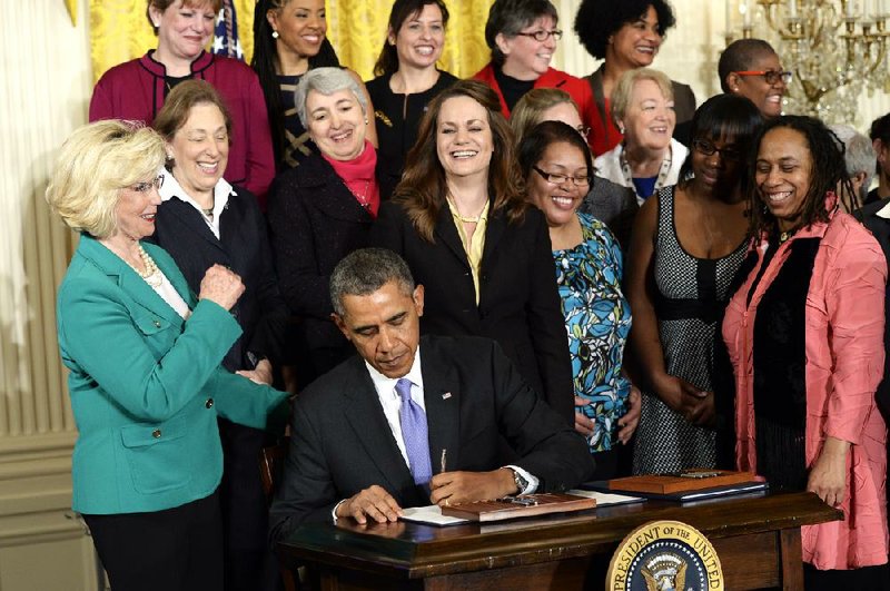 President Barack Obama signs a pay-equity executive action Tuesday at the White House. At left is Lilly Ledbetter, who has become a symbol of the pay-gap issue. 