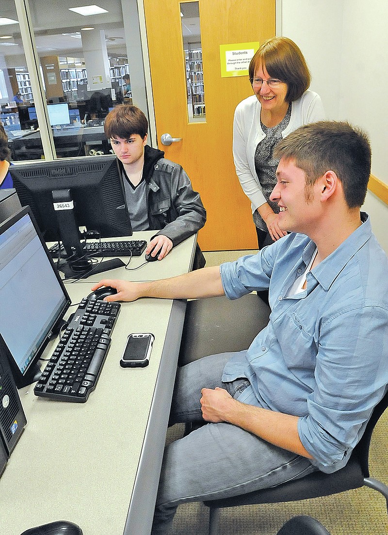 STAFF PHOTO FLIP PUTTHOFF Trenton Dunn, right, a student at Pea Ridge High School, learns about student financial assistance Wednesday from Ann Turner with the financial aid office at NorthWest Arkansas Community College. Students learned about the enrollment process and toured the campus.