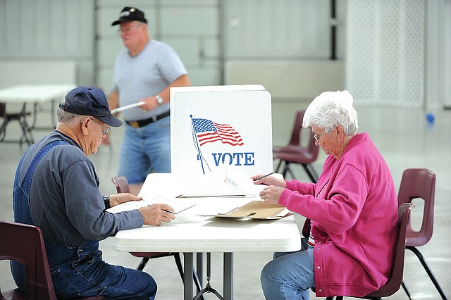 STAFF PHOTO ANDY SHUPE Mitch McCorkle, longtime fire chief for West Fork, and his wife, Henryetta, vote Tuesday in a special election to decide the mayor of West Fork at The Frank Wenzel Community Center.