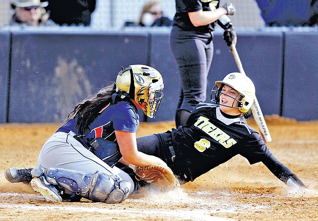  STAFF PHOTO JASON IVESTER Bentonville's Faith Vickers slides into home Tuesday for a run ahead of the tag attempt by Rogers Heritage catcher Abigail Newton in the fourth inning at Bentonville.
