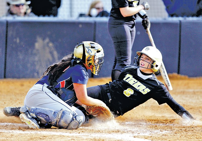  STAFF PHOTO JASON IVESTER Bentonville's Faith Vickers slides into home Tuesday for a run ahead of the tag attempt by Rogers Heritage catcher Abigail Newton in the fourth inning at Bentonville.