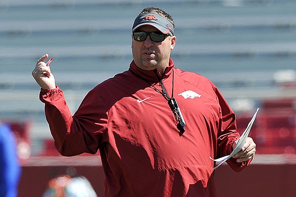 Arkansas coach Bret Bielema watches his team warm up during practice Saturday morning at Razorback Stadium in Fayetteville. 