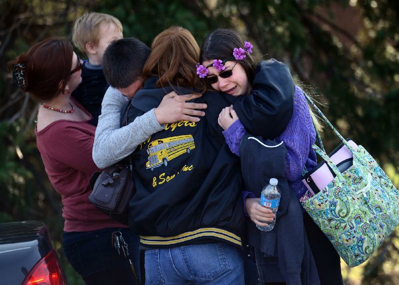 Parents and students comfort one another Wednesday outside a high school in Murrysville, Pa., where a teenager stabbed and slashed 21 students and a security guard and set off a screaming stampede before an assistant principal tackled him. At least five students were critically wounded.