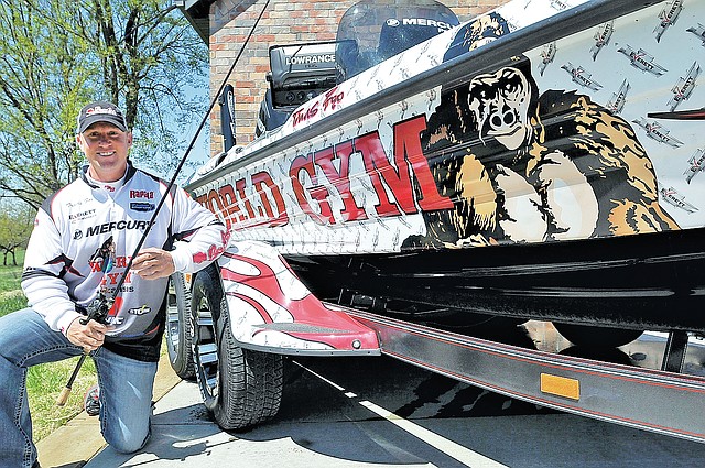 STAFF PHOTO FLIP PUTTHOFF Travis Fox of Rogers, an FLW pro angler, shows artwork Wednesday that decorates his bass boat. Graphics on the boats and vehicles of fishermen are moving billboards that promote their sponsors.