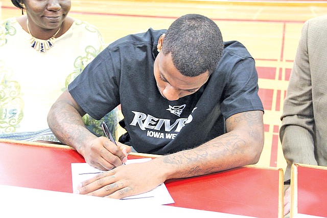Special To NWA Media D.J. Evans, Springdale High senior, signs a letter of intent to play for the Iowa Western Community College basketball team next season during a ceremony Wednesday at Springdale.