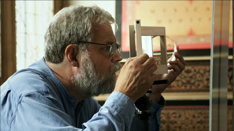 Tim Jenison fiddles with a lens as he attempts to construct a device that will allow him to replicate the effects achieved by the 17-century Dutch master Johannes Vermeer in the documentary Tim’s Vermeer. 