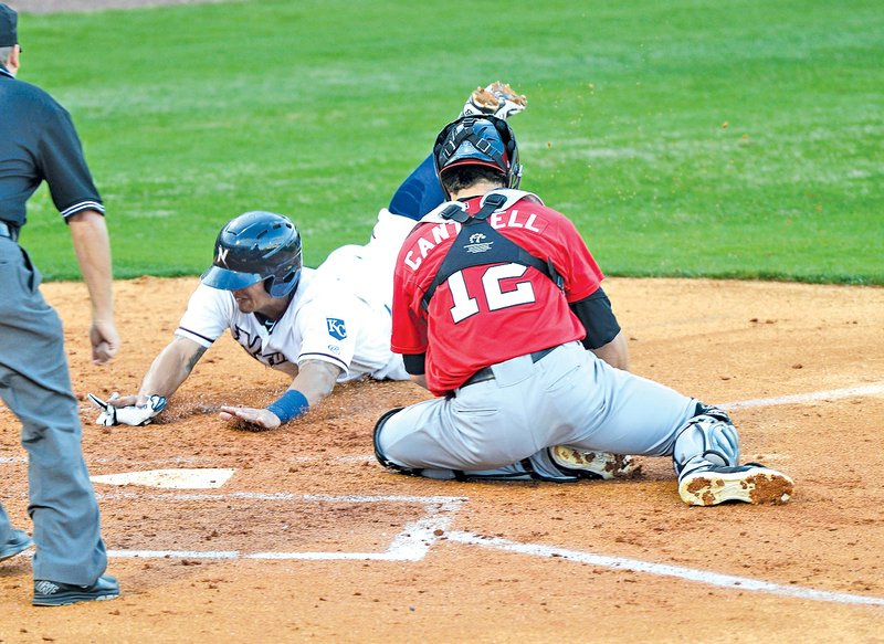  STAFF PHOTO ANTHONY REYES Cheslor Cuthbert of the Northwest Arkansas Naturals slides home as Frisco&#8217;s Patrick Cantwell tries to apply the tag Thursday at Arvest Ballpark in Springdale. Cuthbert was safe on the play.