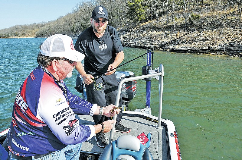 STAFF PHOTO FLIP PUTTHOFF Jeff Thompson, left, founder of Operation Troop Salute, helps Brad Belt of Mulberry select the right lure Thursday for a morning of fishing at Beaver Lake. Belt is a disabled Arkansas National Guard veteran with post-traumatic stress disorder after his service in Iraq. Thompson and his wife, Carol, follow the FLW Tour and take disabled veterans fishing during FLW tournaments.