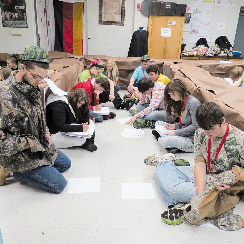 From left, Nick Middleton, Crystal Mitchell, Garrett Sherrill, Sydney Wader, Alli Shock, Dylan Duncan, Paris Carpenter, Adam Barnard, Lindsey Bates and Kolten Reinier sit on the floor in Candace Churchwell’s classroom simulating the trenches of World War I.