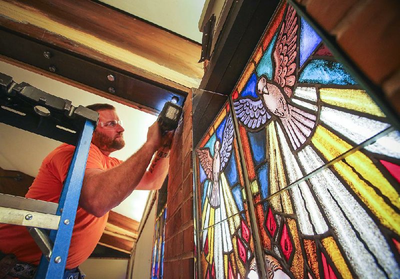 12/18/13
Arkansas Democrat-Gazette/STEPHEN B. THORNTON
Zack Wray, with Glue Lam Erectors Inc., of Trafalgar, Indiana, screws on a piece of wood trim on a laminated wood beam inside Little Rock's St. Mark's Episcopal Church sanctuary. Termites were discovered this summer in the sanctuary's large, wooden support beams forcing services into the church's Parish Hall. This will be the first time in nearly 50 years that Christmas services won't be held in the sanctuary. Rector Danny Schieffler says that despite the location change he has actually seen a rise in attendance. 