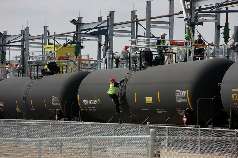 Employees fill a tank car with oil at the Musket Corp. Windsor Crude Terminal in Windsor, Colo., earlier this month. Increases in the amount of crude oil moved by rail is one of the reasons shipments of commodities have snarled across the country. 
