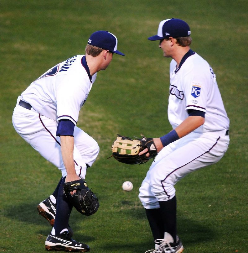 Northwest Arkansas pitcher Sam Selman (left) and first baseman Jared Schlehuber converge on Luis Sardinas’ pop-up in the second inning Friday night at Arvest Ballpark. Selman dropped the ball for an error, which allowed a run to score in Frisco’s 2-1 victory. Selman struck out four in five innings in his Class AA debut. 