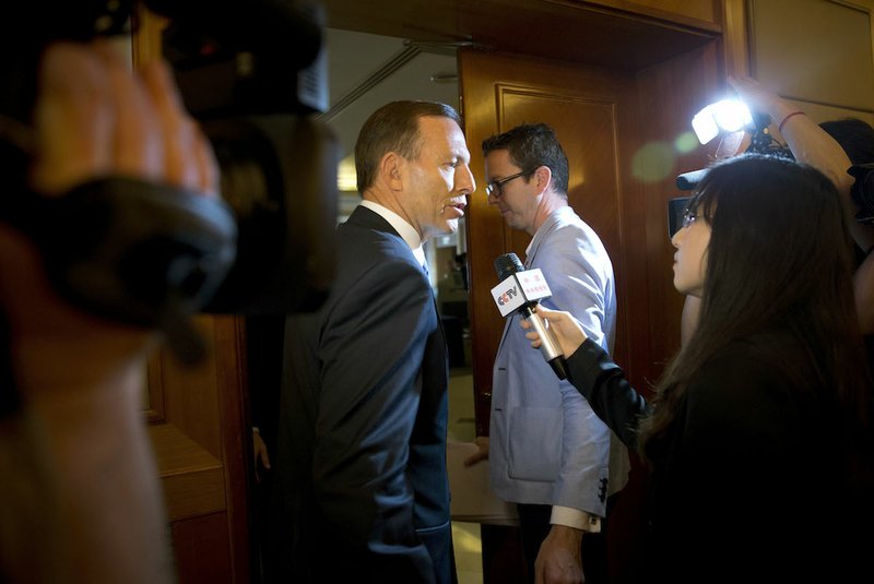Australian Prime Minister Tony Abbott, center, is questioned by a Chinese TV reporter about the missing Malaysian Airlines Flight 370 after a press conference Saturday at a hotel in Beijing, China. With no new underwater signals detected, the search for the missing Malaysian passenger jet resumed Saturday in a race against time to find its dying black boxes five weeks after families first learned their loved ones never arrived at their destination. 
